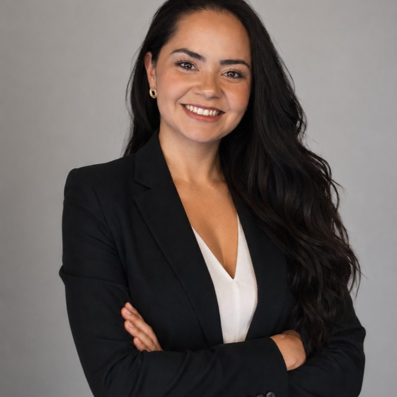 Portrait of bella rauj in a black blazer, arms crossed, smiling