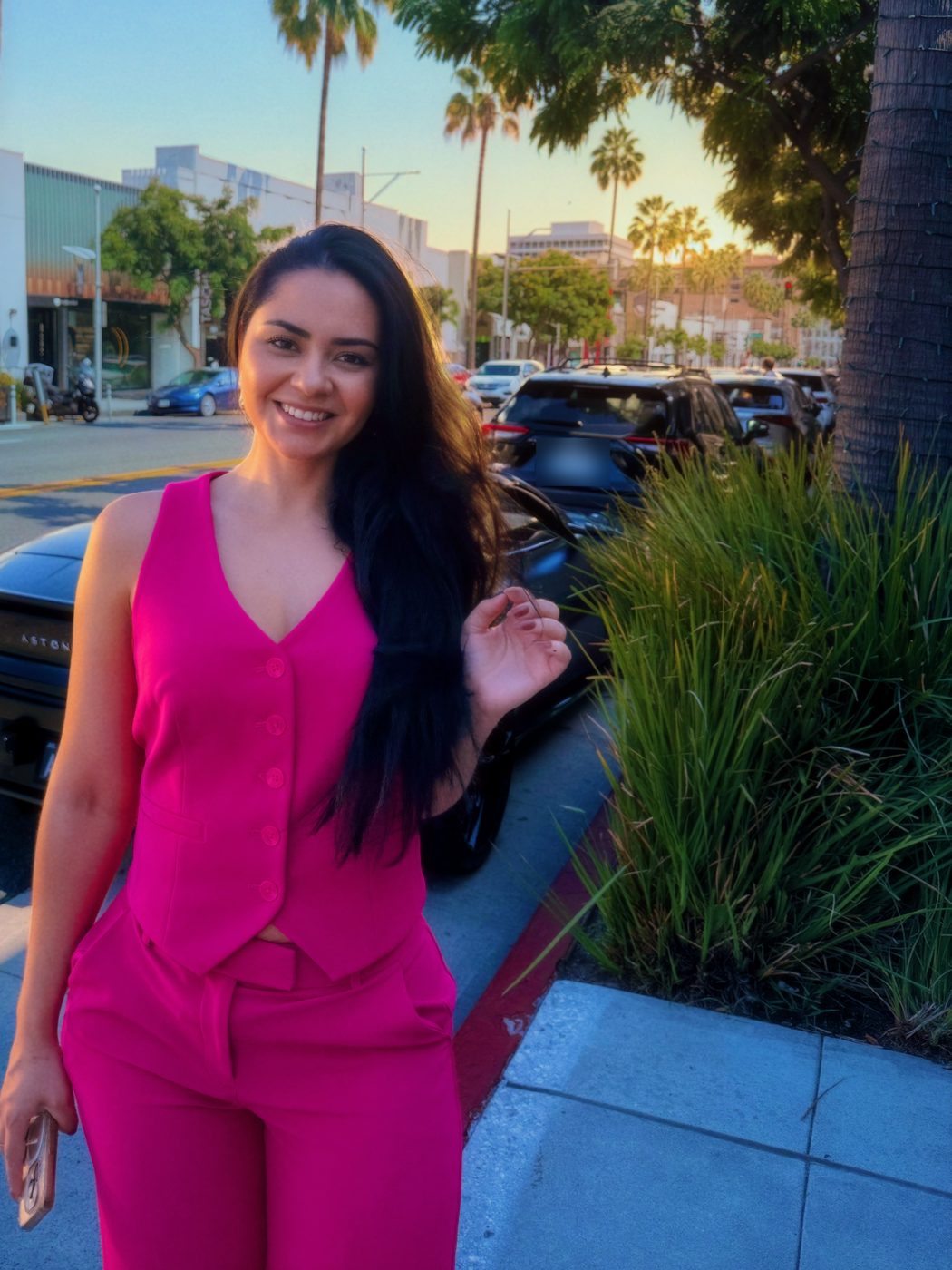bella rauj in a pink suit on a sunny street