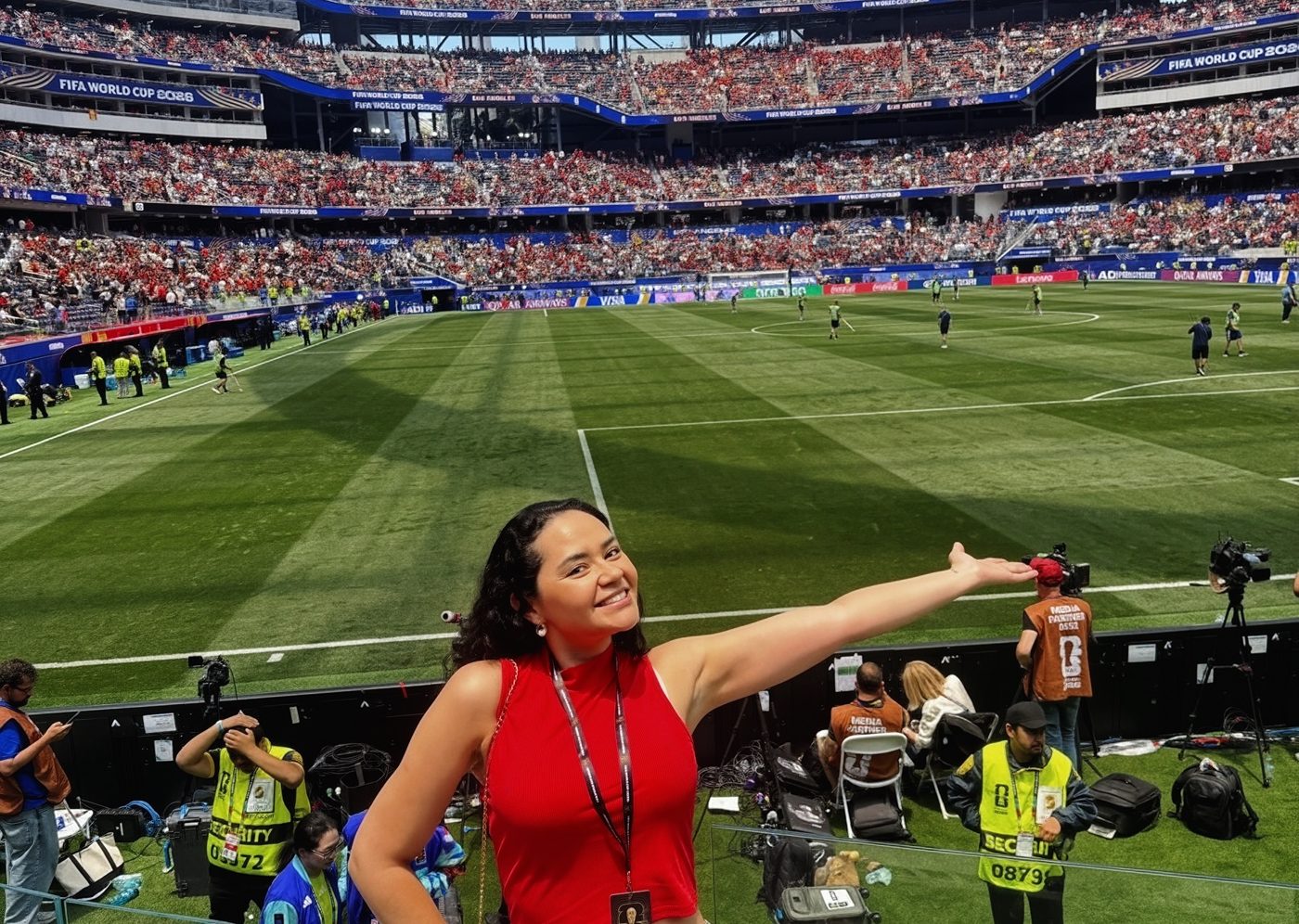 bella rauj pitchside at a World Cup match, pointing to the field